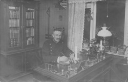 Landbetjent Søren Christian Harplod ved sit arbejdsbord i villa Justitia, 1913.
