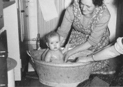 Badefoholdene var mere primitive i sidste og forrige århundrede. Her bades et lille barn i en balje i køkkenet, ca. 1930.
